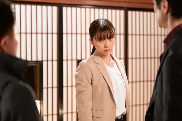 Woman faces two men in traditional room in "Metropolitan Police Department Outsider".